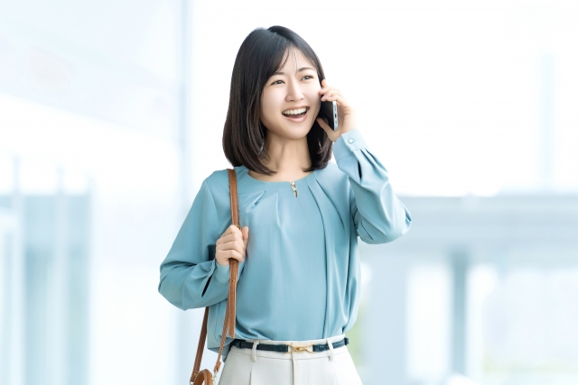 スマホで通話しながら歩く女性