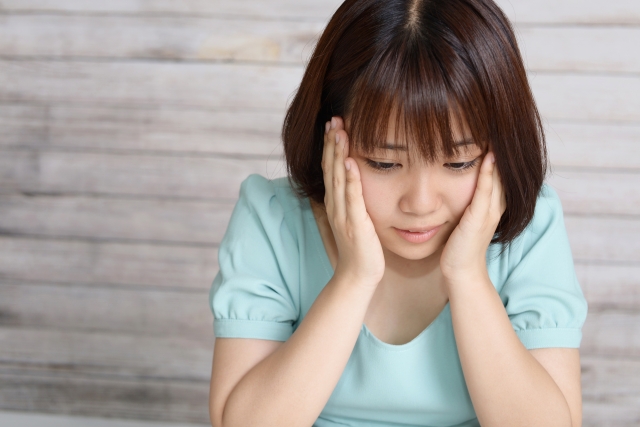 水色の服を着た落ち込む女性