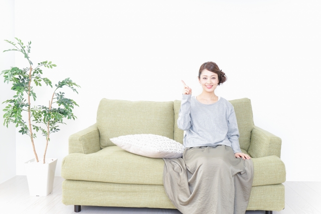 ソファーで指をさす女性